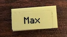 Display of LEGO part no. 3069pb0743 which is a Tan Tile 1 x 2 with 'Max' Pattern (Sticker), Set 21144 