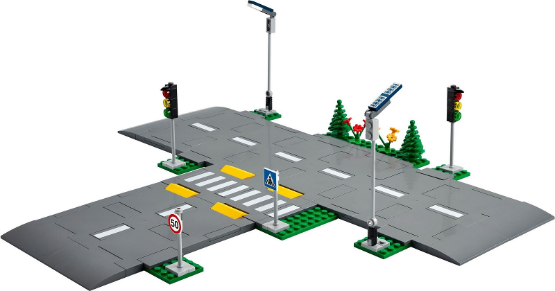 Model of a road intersection with traffic lights, signs, and crosswalks on a white background