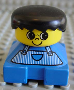 Display of LEGO Duplo Duplo 2 x 2 x 2 Figure Brick, Blue Base, Striped Overalls, Black Hair, Large Eyes, Freckles on Nose