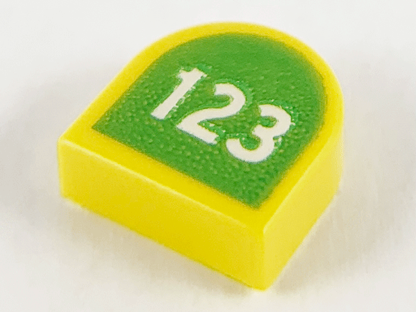 Display of LEGO part no. 24246pb008 Tile, Round 1 x 1 Half Circle Extended with White '123' on Lime Background Pattern  which is a Yellow Tile, Round 1 x 1 Half Circle Extended with White '123' on Lime Background Pattern 