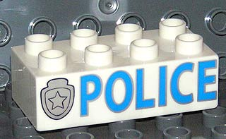 Display of LEGO part no. 3011pb019 Duplo, Brick 2 x 4 with 'POLICE' and Star Badge Silver Pattern  which is a White Duplo, Brick 2 x 4 with 'POLICE' and Star Badge Silver Pattern 