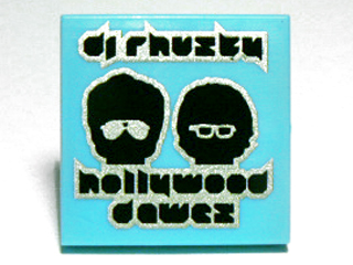 Display of LEGO part no. 3068bpb0593 Tile 2 x 2 with Groove with 'dj rhusty', 'hollywood dawez' and Black Heads with Glasses Pattern  which is a Medium Azure Tile 2 x 2 with Groove with 'dj rhusty', 'hollywood dawez' and Black Heads with Glasses Pattern 