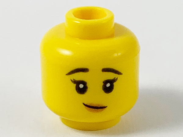 Display of LEGO part no. 3626cpb2600 Minifigure, Head Female Black Raised Eyebrows, Lopsided Smile with Peach Lips Pattern, Hollow Stud  which is a Yellow Minifigure, Head Female Black Raised Eyebrows, Lopsided Smile with Peach Lips Pattern, Hollow Stud 