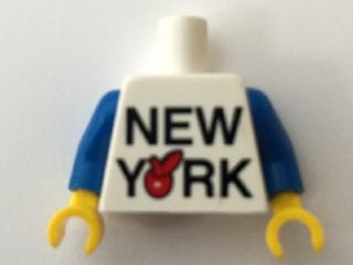 Display of LEGO part no. 973pb2326c01 which is a White Torso 'NEW YORK' Big Red Apple Pattern / Blue Arms / Yellow Hands 