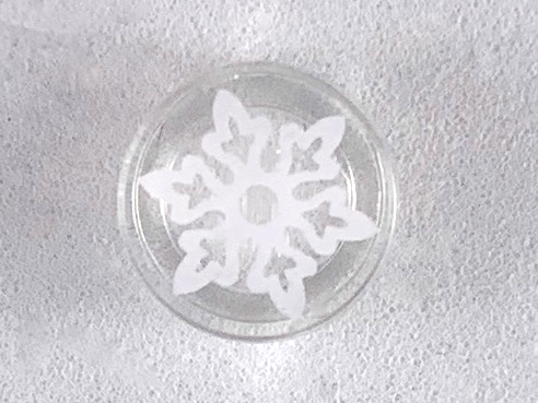 Display of LEGO part no. 98138pb104 which is a Trans-Clear Tile, Round 1 x 1 with White Snowflake with 6 Points Pattern 